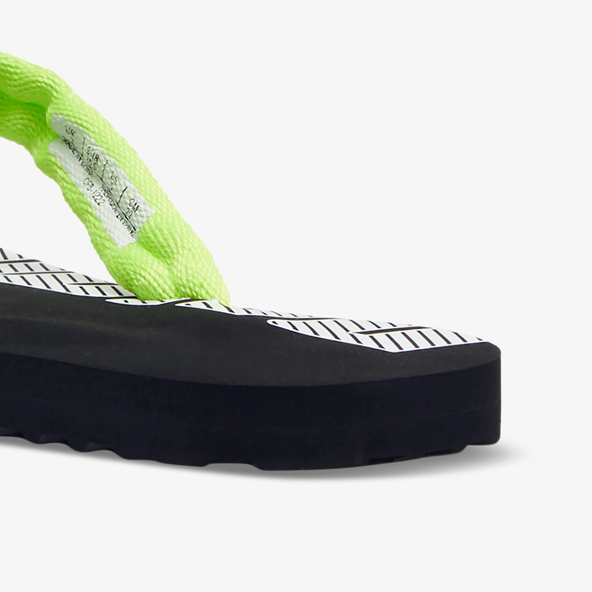 Detailaufnahme eines Schuhs mit neongrünem gepolstertem Riemen und robuster schwarzer Sohle