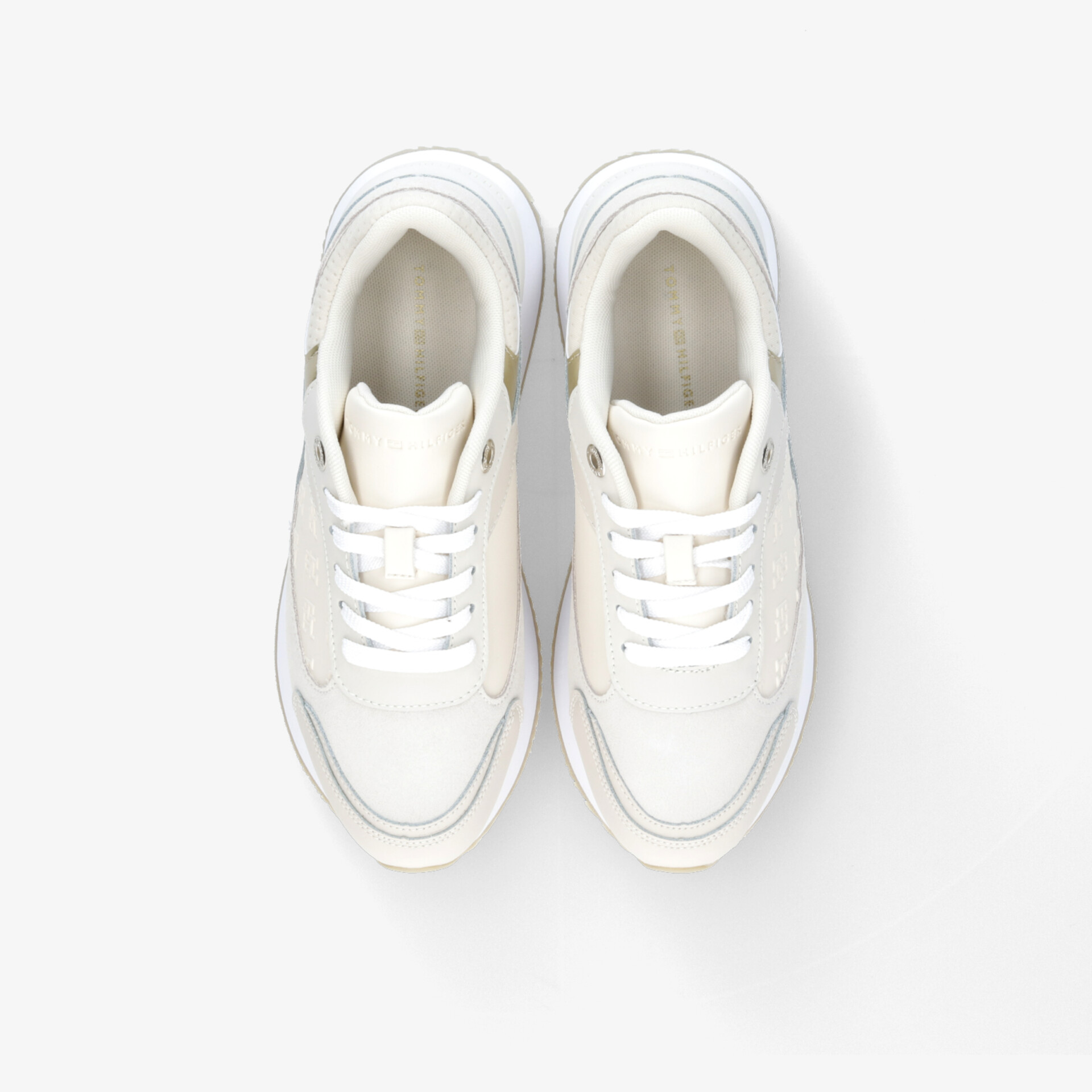 Moderne weiße Sneaker aus der Vogelperspektive, betont schlichten Stil und sportliche Eleganz.
