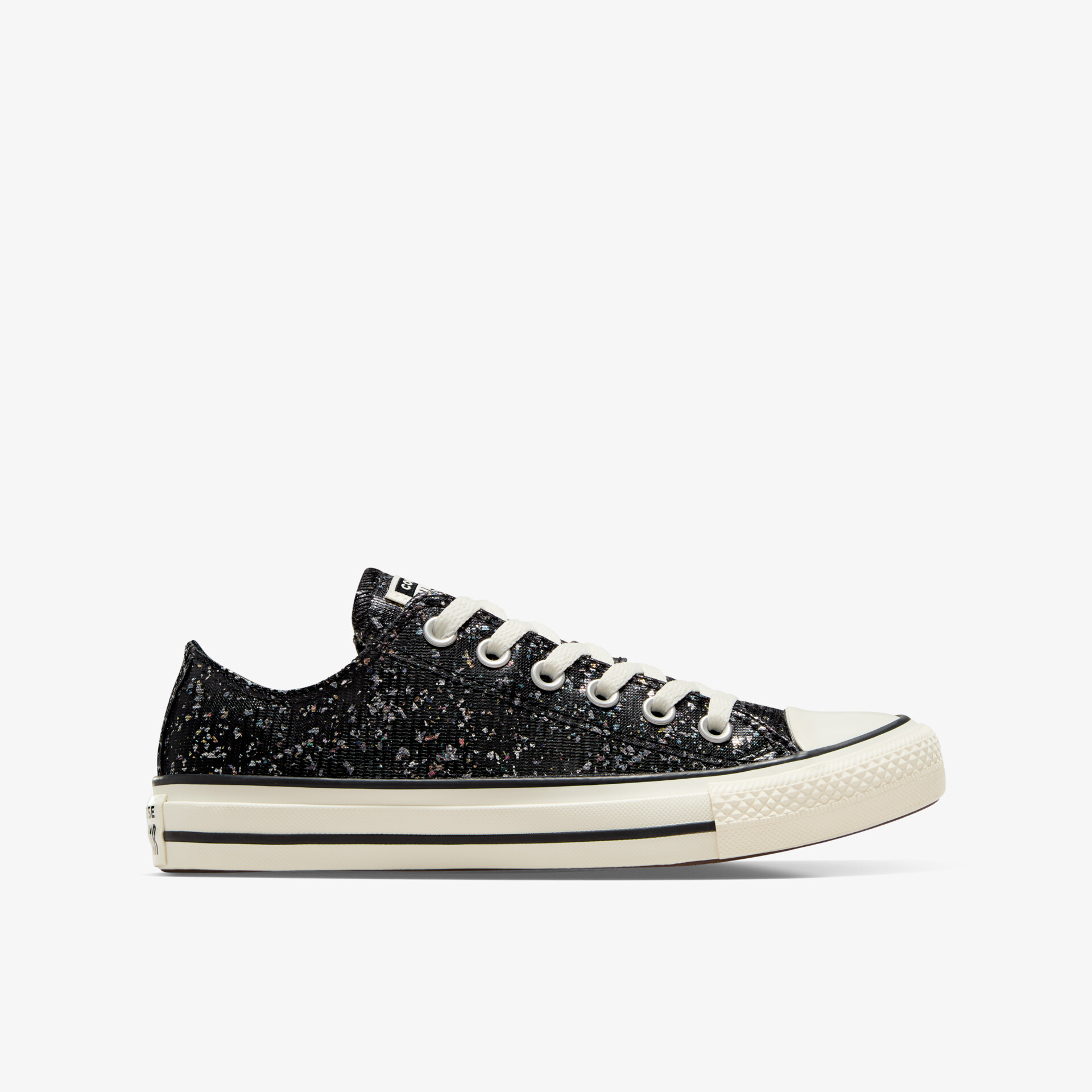 Seitenansicht eines schwarzen glitzernden Sneakers mit weißen Schnürsenkeln und robuster Sohle, modisch und bequem