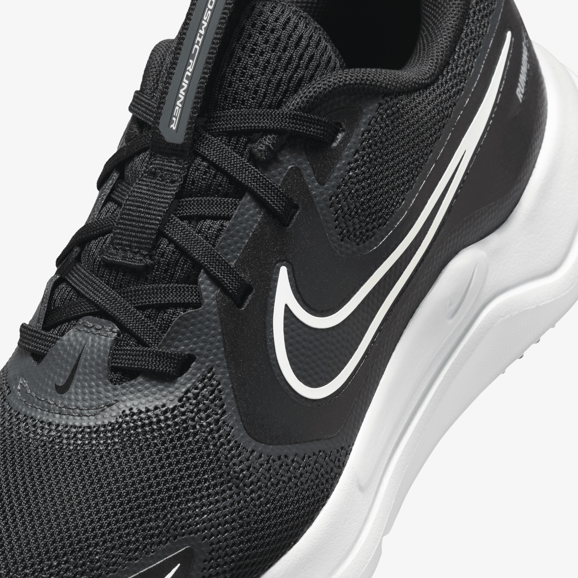 Detailaufnahme eines schwarzen Sportschuhs mit atmungsaktiver Mesh-Oberfläche, bequemer Schnürung und weißem Nike-Logo