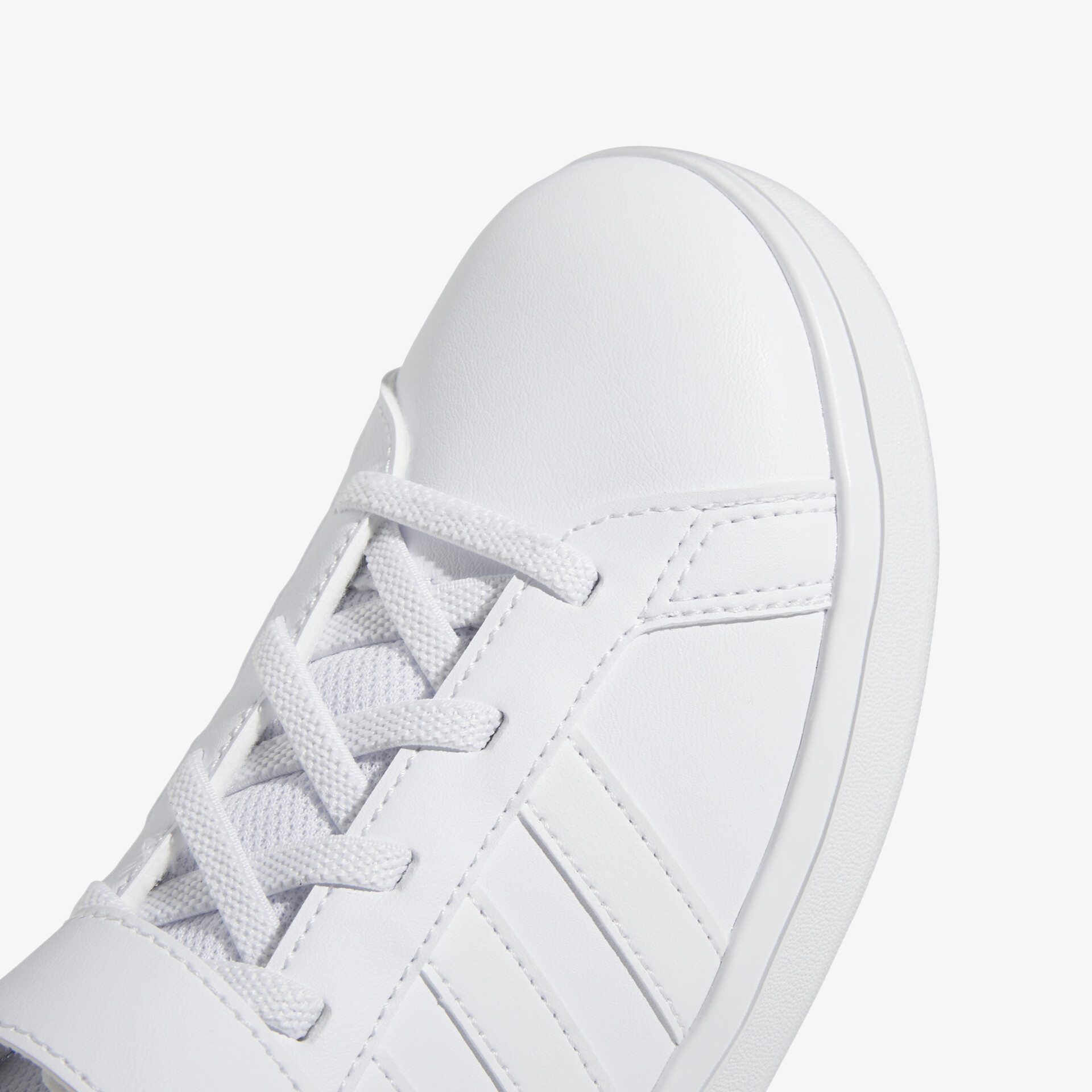 Detailaufnahme eines weißen Sneakers mit sauber gearbeiteten Schnürsenkeln und glatter Oberfläche