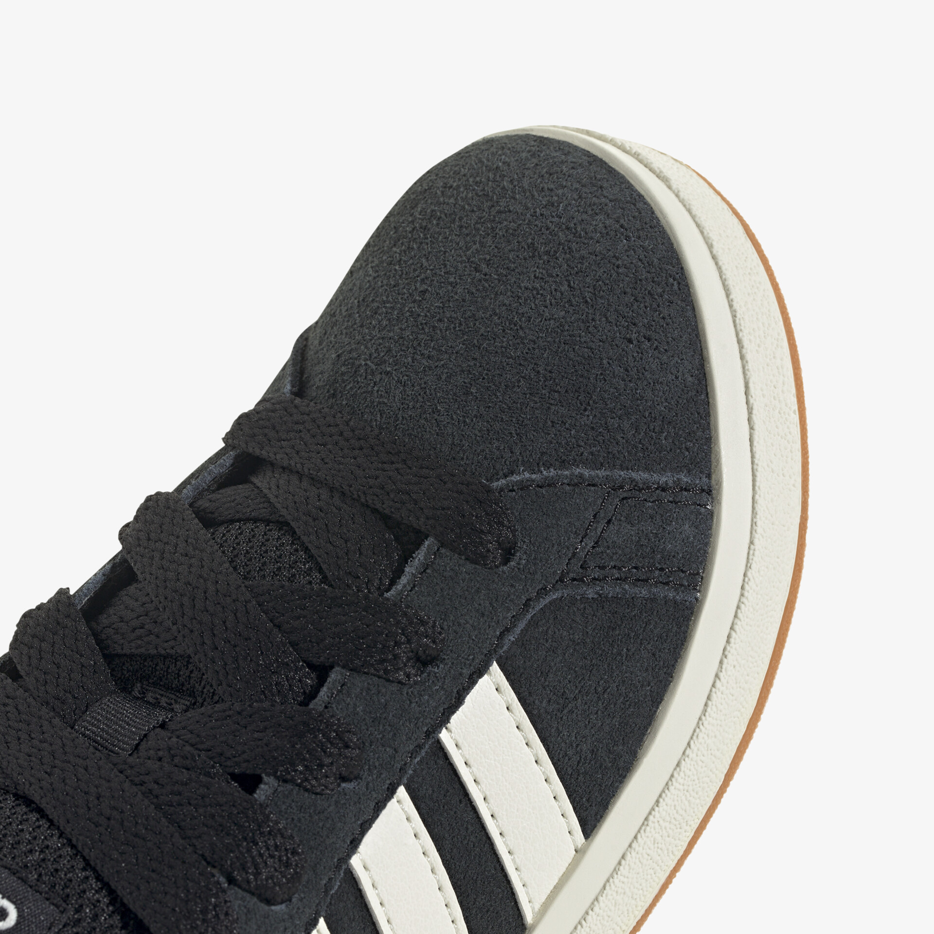 Detailaufnahme schwarzer Sneaker mit weißen Streifen und schwarzer Schnürung, hochwertiges Material sichtbar