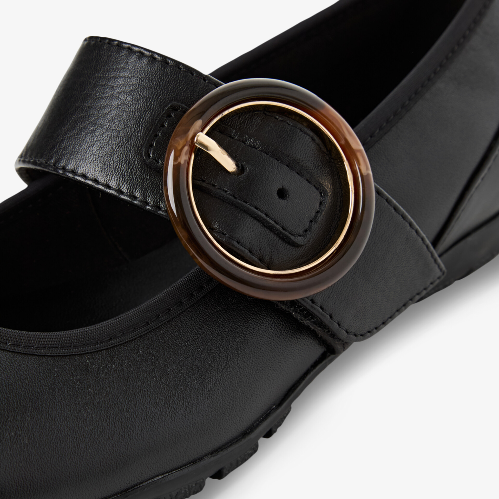 Schwarzer Schuh aus hochwertigem Leder mit robuster, goldfarbener Schnalle in eleganter Nahaufnahme