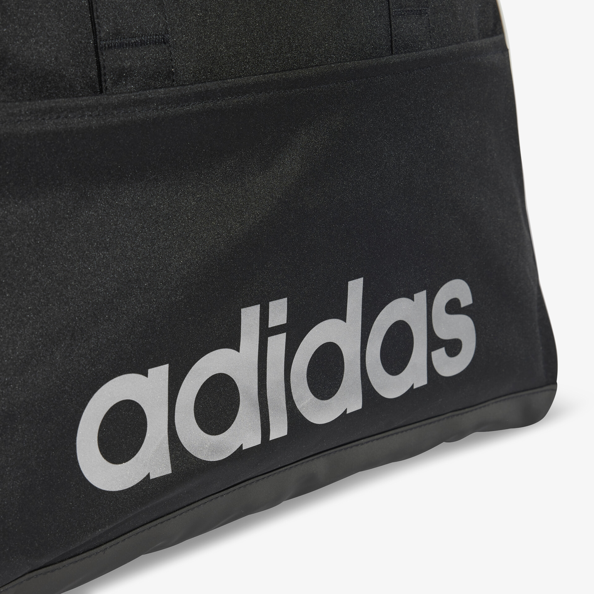 Detailaufnahme des klaren adidas Logos in prägnanter Schrift auf schwarzem Hintergrund