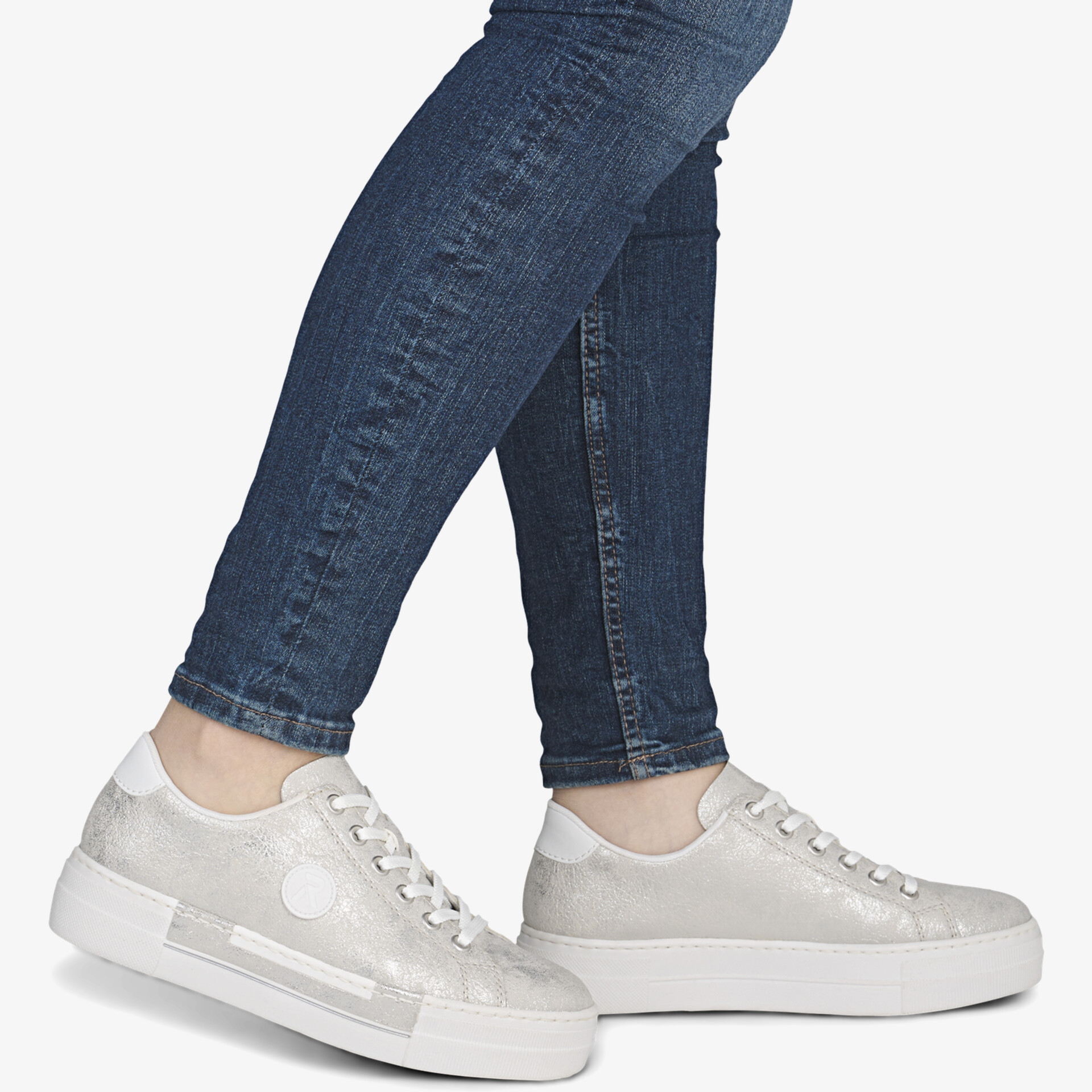 Stilvolle weiße Sneaker, kombiniert mit Jeans, bieten Komfort und Alltagstauglichkeit.