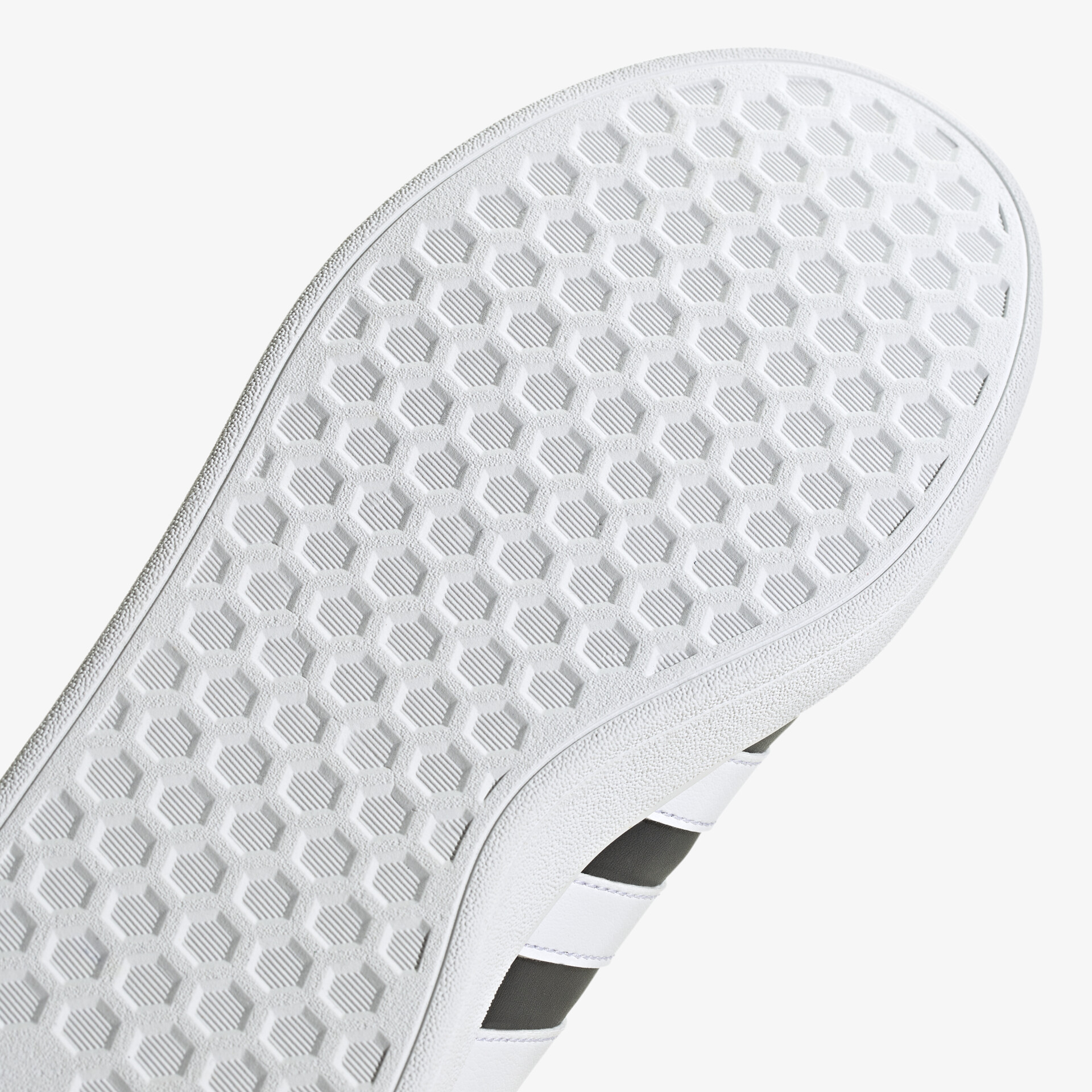 Detailaufnahme einer weißen Schuhsohle mit Hexagonstruktur für optimale Traktion und stilvolles Design.