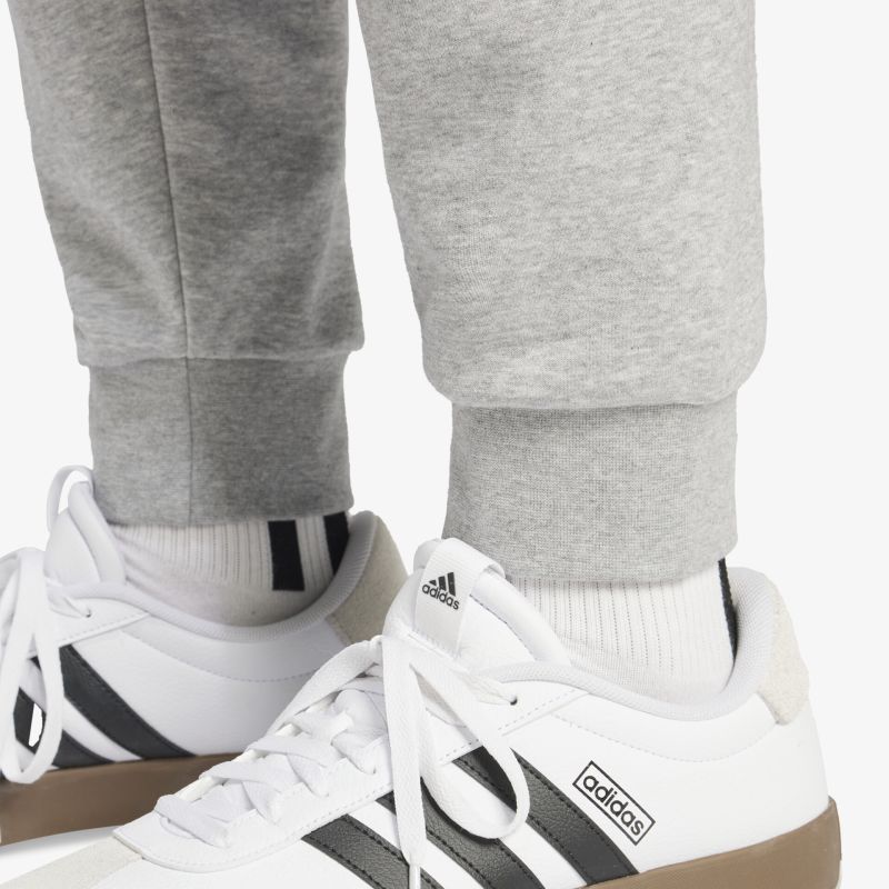 Bequeme weiße Freizeitschuhe mit schwarzem Streifen, gepolsterter Schaft und flexibler, rutschfester Sohle getragen