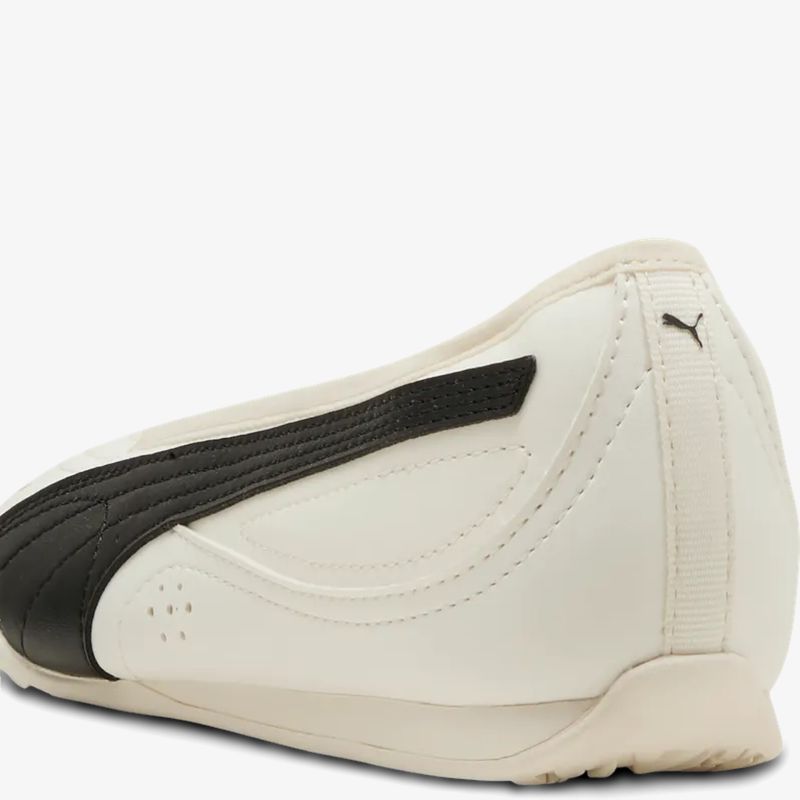 Seitliche Ansicht eines weißen Puma Sneakers mit markantem schwarzem Streifen und sportlichem Design