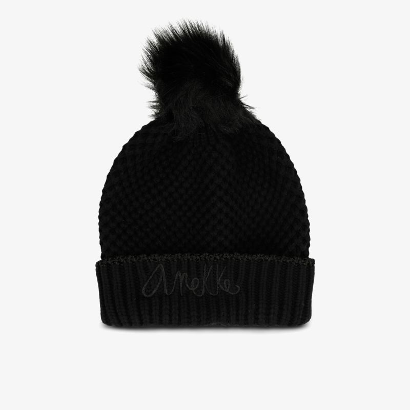 Elegante schwarze Bommelmütze, gestrickte Struktur, modisches Accessoire für kühle Tage