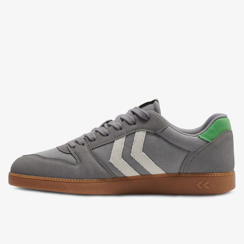 Grauer Sneaker seitliche Ansicht mit grünem Fersenakzent und flexibler brauner Sohle für komfortablen Tragekomfort