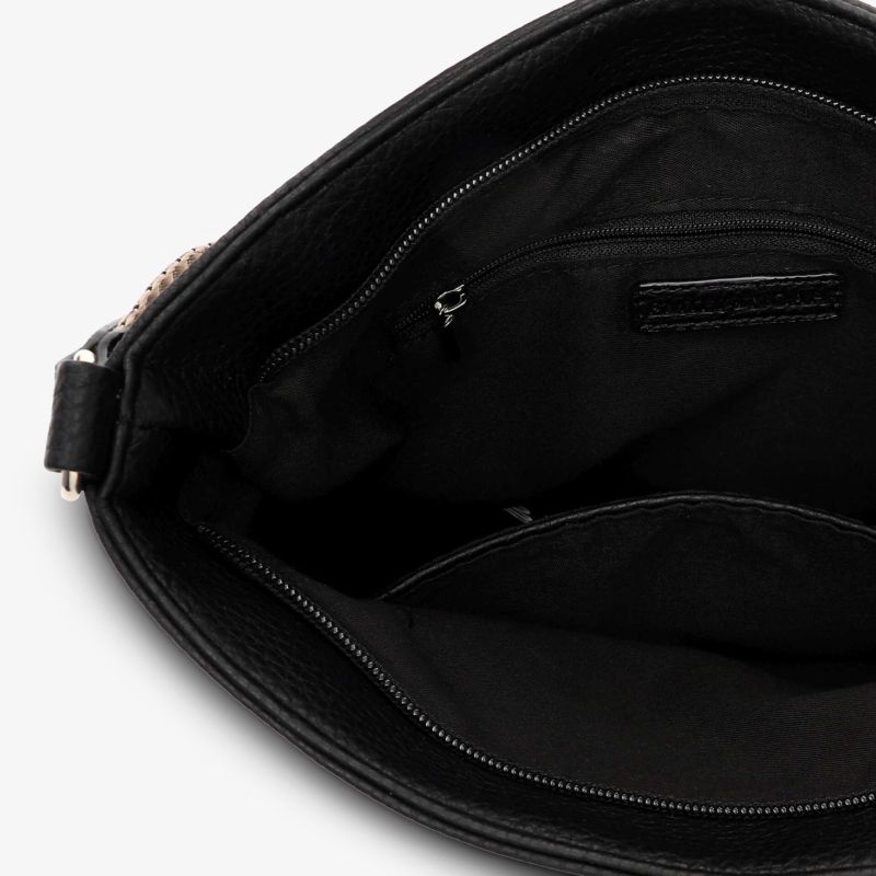 Innenansicht einer schwarzen Tasche mit geräumigem Hauptfach und praktischen Reißverschlussfächern