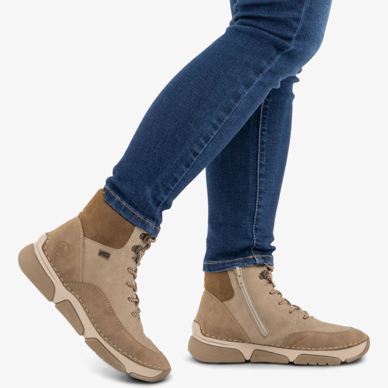 Bequeme beige Veloursleder Stiefeletten mit Reißverschluss und flexibler Sohle werden am Fuß getragen