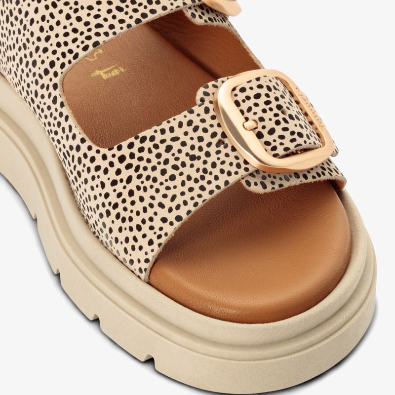 Stylische Sandale mit gepunktetem Muster und verstellbarem Riemen, ideal für den Sommer.