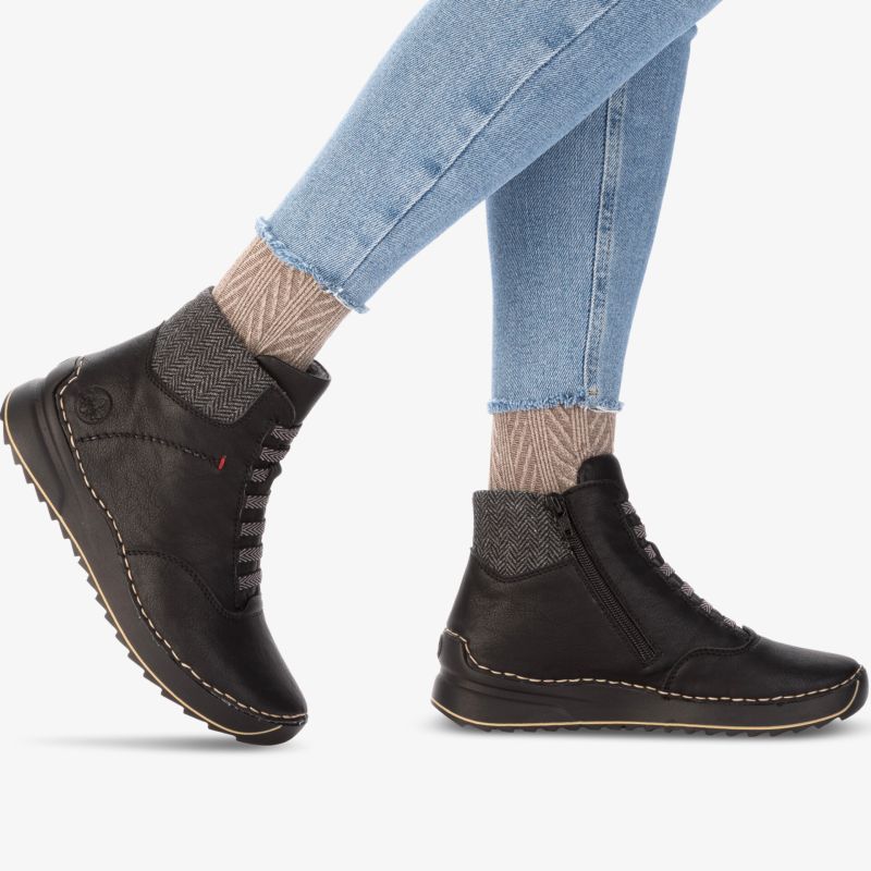 Bequeme schwarze Stiefelette mit flexibler Sohle in seitlicher Ansicht getragen