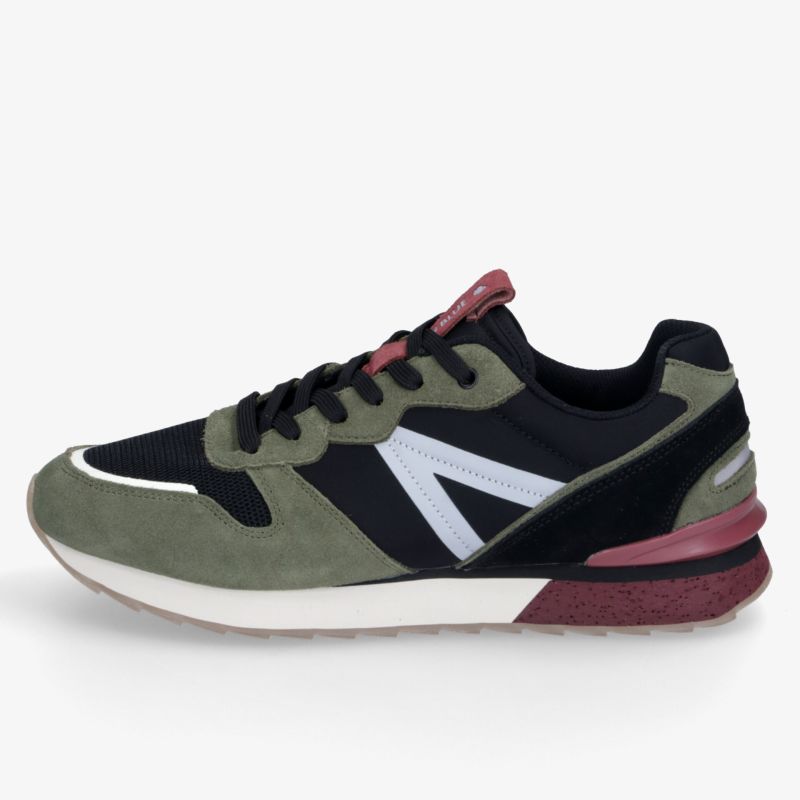 Sportlicher Sneaker in Grün, Schwarz und Weiß mit markanter Sohle und dynamischem Design, schräg von vorn
