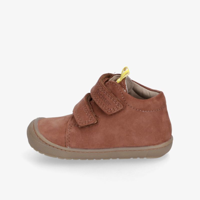 Seitliche Ansicht eines braunen Velourslederschuhs mit Klettverschluss und rutschfester, flexibler Sohle