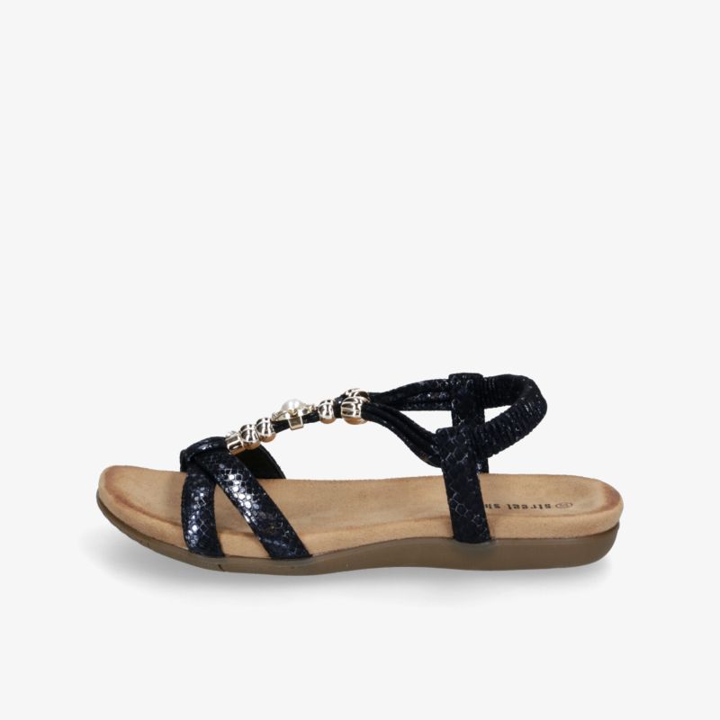 Seitliche Ansicht einer eleganten schwarzen Sandale mit verziertem Riemen und bequemer flacher Sohle