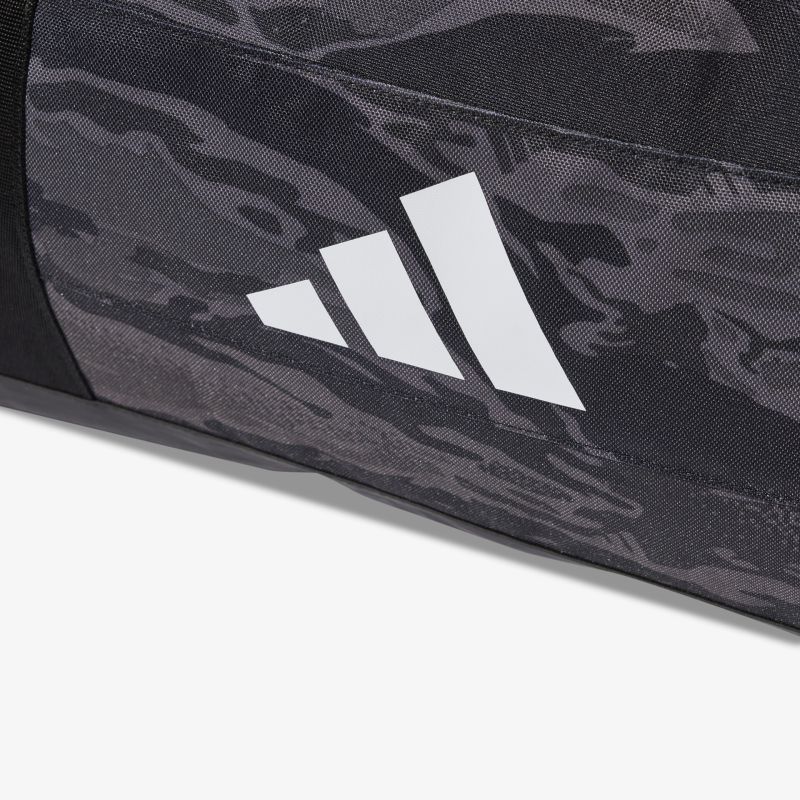 Detailaufnahme des Adidas Logos auf dunkel meliertem Material mit robuster Textur