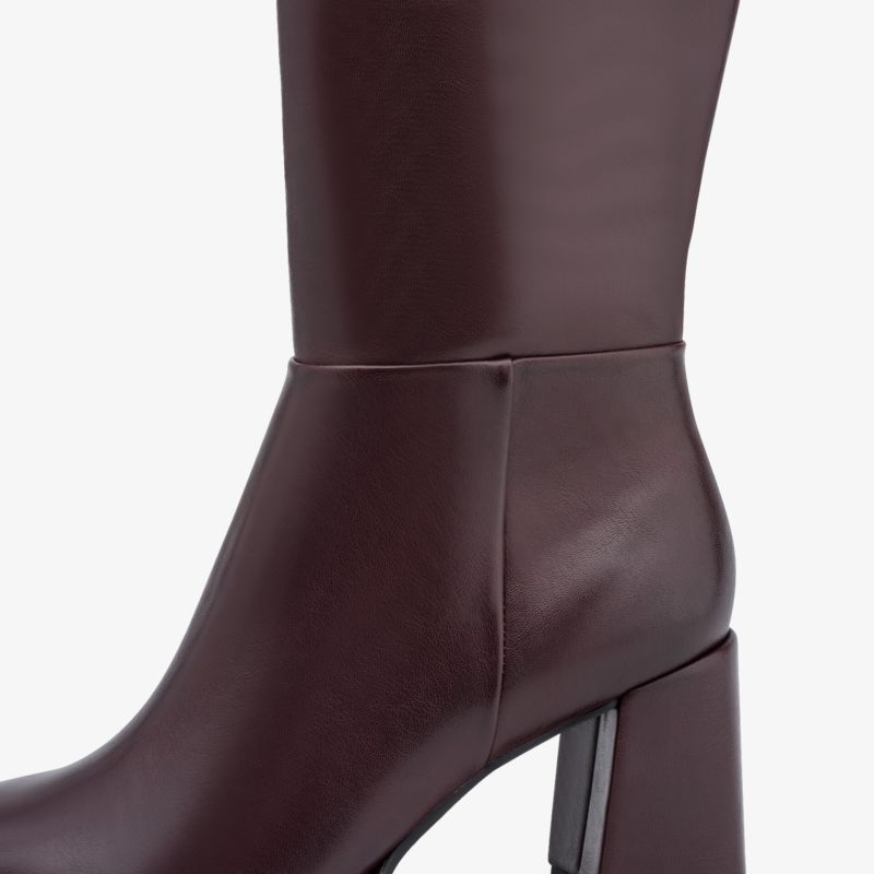 Moderner brauner Lederstiefel mit hohem Blockabsatz und glatter Oberfläche, elegante Seitansicht