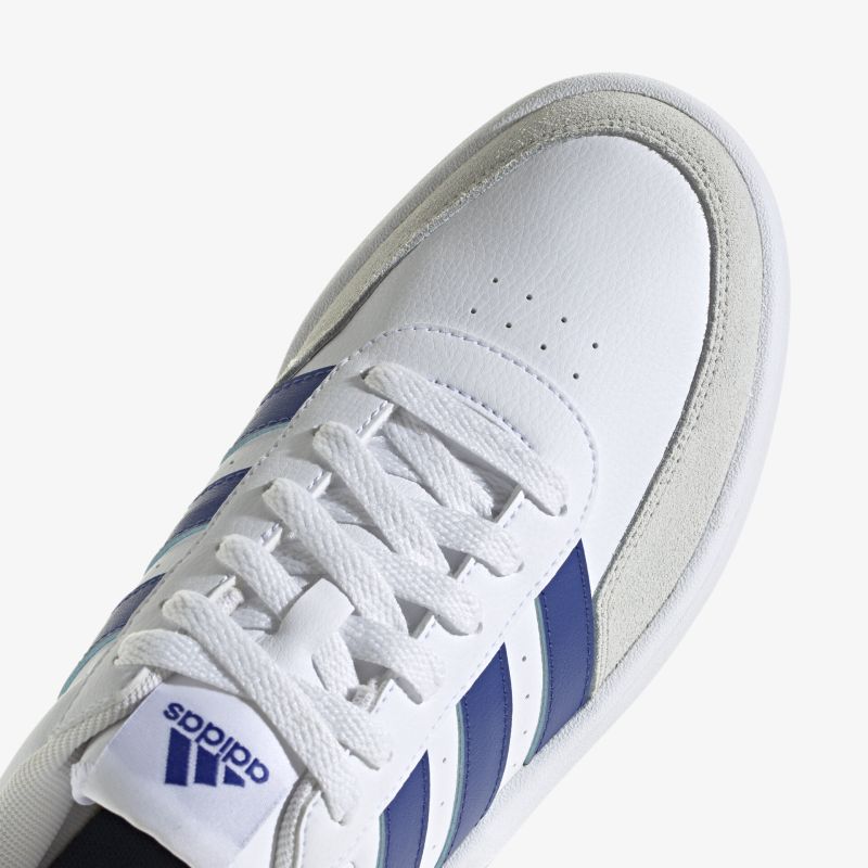 Moderner weißer Sneaker mit blauen Streifen und bequemer Passform, ideal für sportliche Aktivitäten.