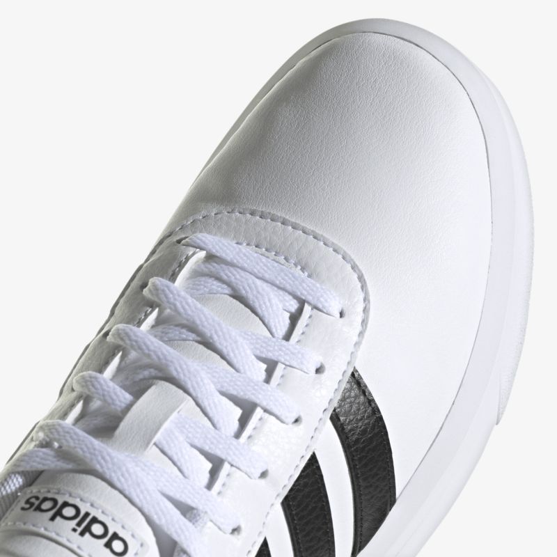 Detailansicht eines weißen Adidas-Sneakers mit schwarzen Streifen und Schnürung