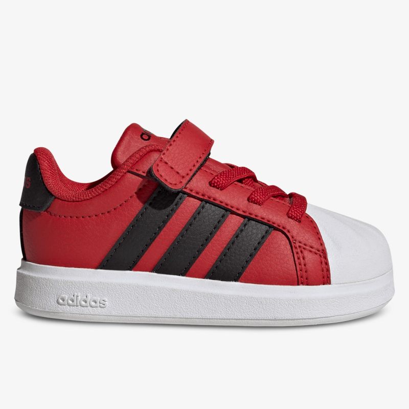 Seitliche Ansicht roter Sneaker mit Klettverschluss und rutschfester weißer Sohle, sportlich und bequem