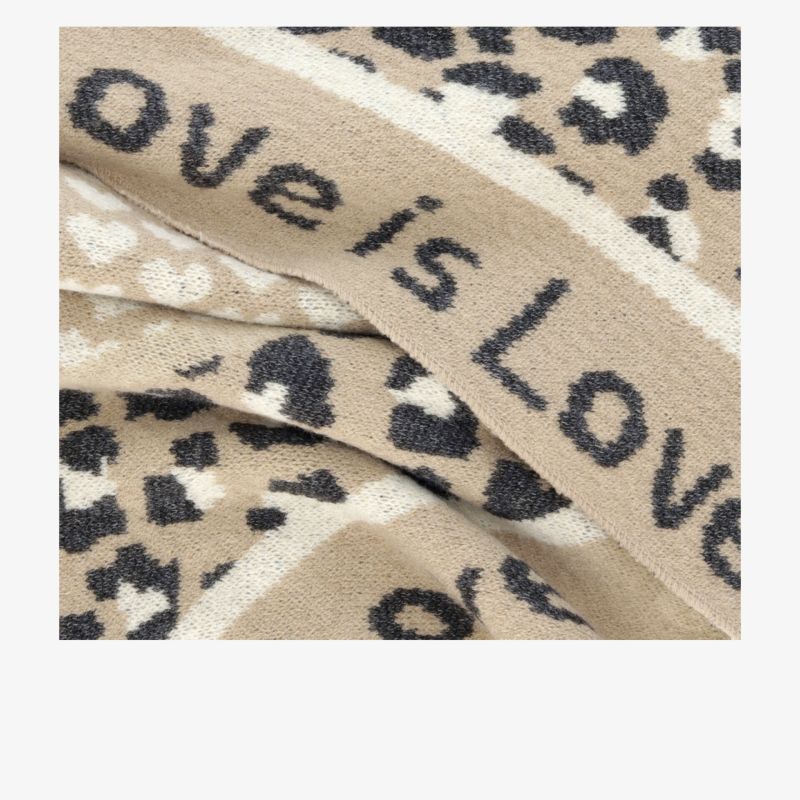 Detailaufnahme eines weichen beigen Stoffes mit Leopardmuster und klarem "love is love" Schriftzug