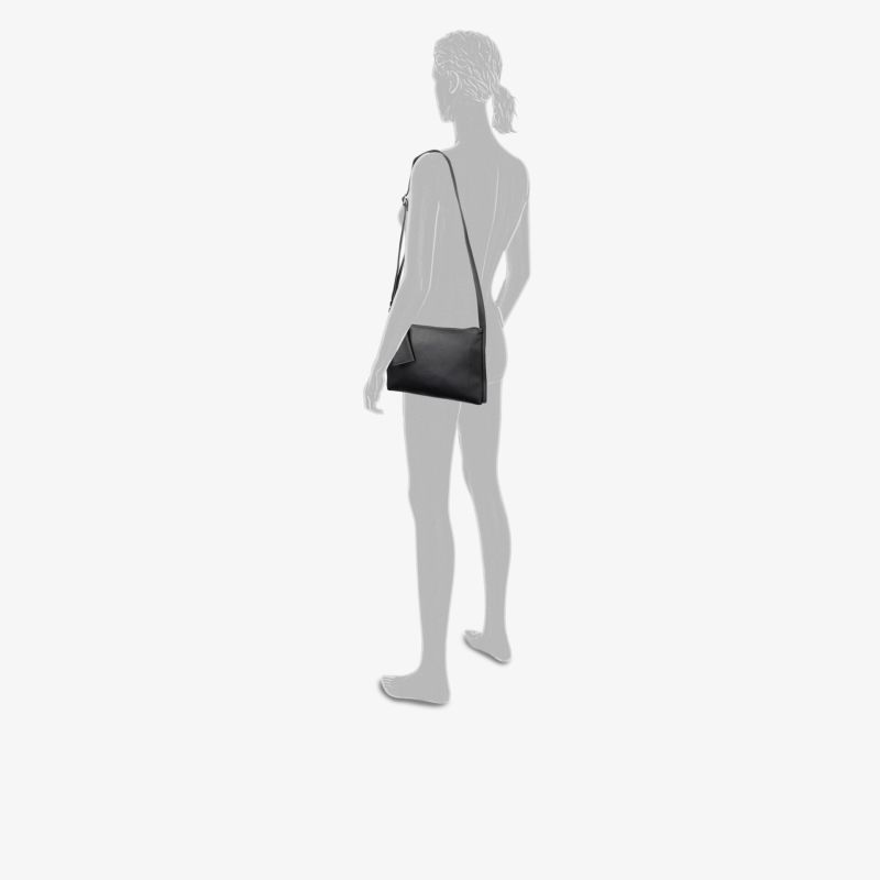 Kompakte schwarze Schultertasche mit schlichter, funktionaler Form und modernem Design, gezeigt in seitlicher Ansicht getragen
