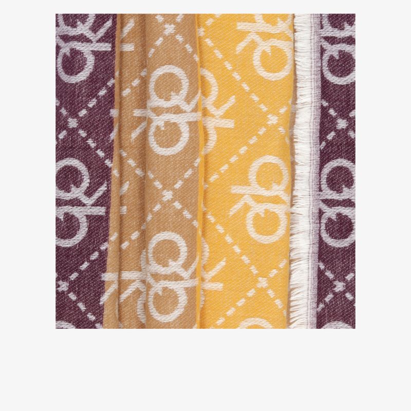 Detailaufnahme eines Stoffmusters in braun und gelb mit sichtbaren Nähten und auffälligem Logo-Design