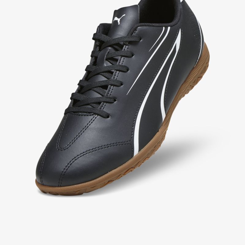 Sportlicher schwarzer Sneaker mit brauner Sohle und weißen Linien in schräger Vorderansicht