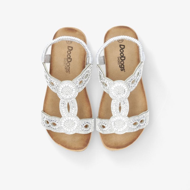 weiße Sandalen mit eleganter Verzierung und bequemem Fußbett in moderner Top-Down-Ansicht