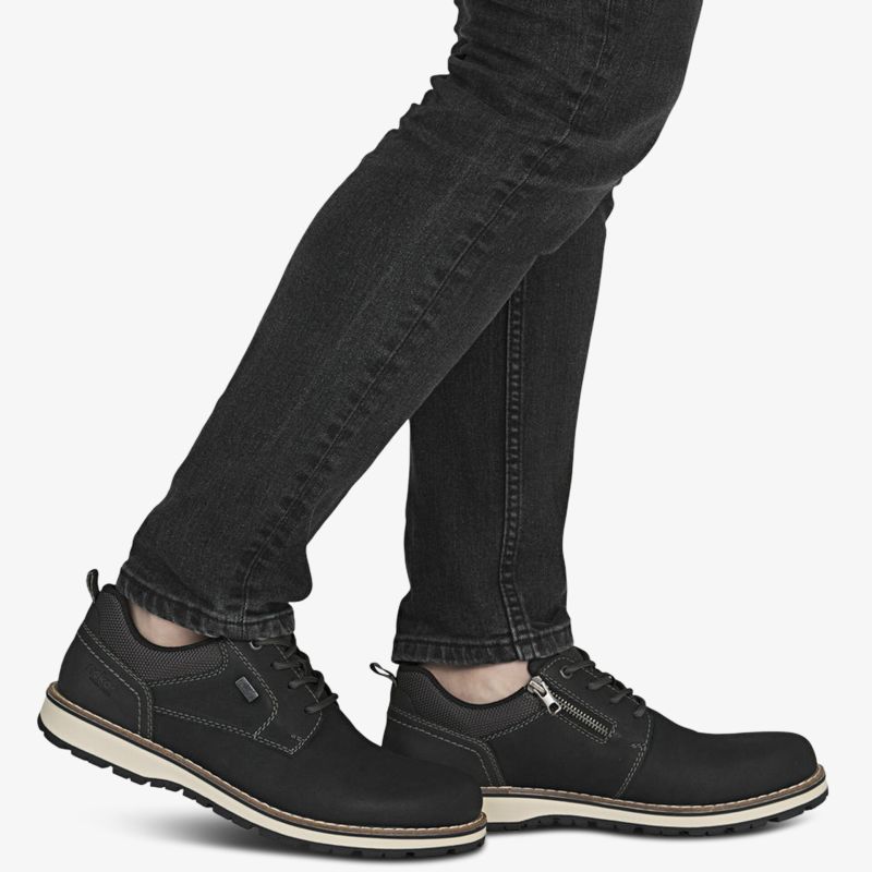 Schwarze sportliche Sneakers mit gepolstertem Schaftrand und rutschfester leichter Sohle, getragen am Fuß