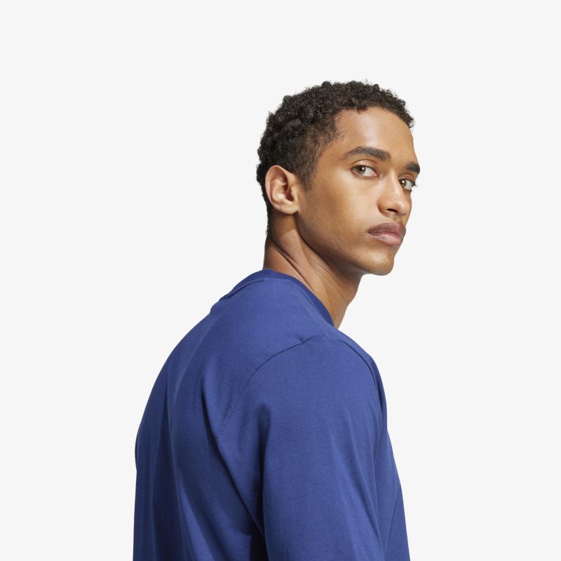 Seitliches Porträt einer Person mit blauem Oberteil, klarer Gesichtskontur und neutralem, selbstbewusstem Ausdruck