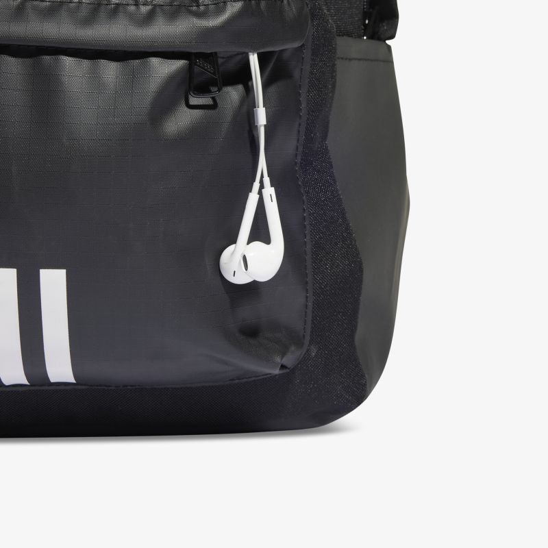 Detailansicht eines schwarzen Rucksacks mit Kopfhörern in der Außentasche, robustes und funktionales Material