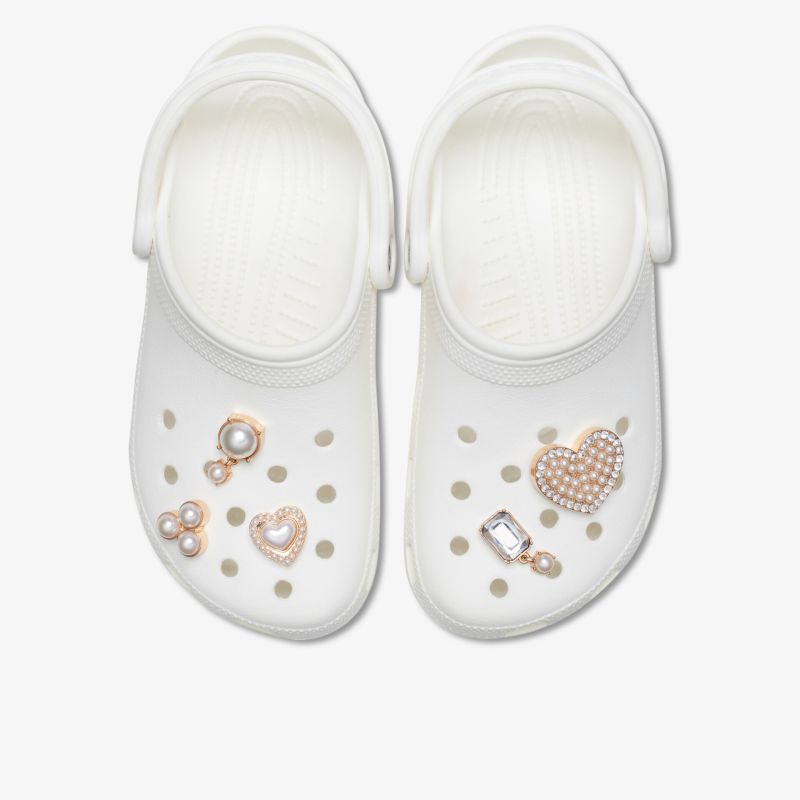 Bequeme weiße Clogs mit dekorativen Schmuckverzierungen, ideal für Freizeit und Garten.