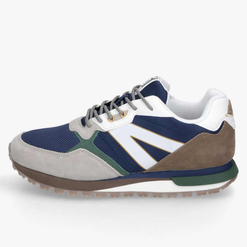 Blau-weißer Sneaker mit grünen Akzenten, markanter Profilsohle und sportlichem Retro-Design in seitlicher Ansicht
