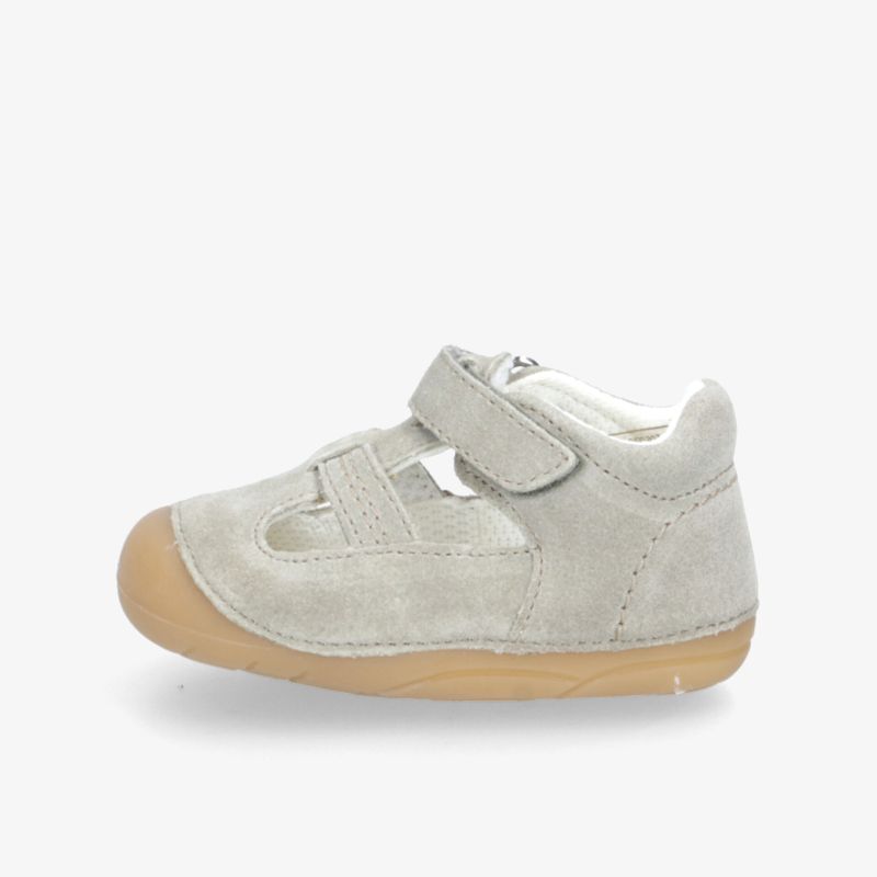 Seitliche Ansicht eines grauen Freizeitschuhs mit Klettverschluss und rutschfester, flexibler Sohle für bequemen Tragekomfort