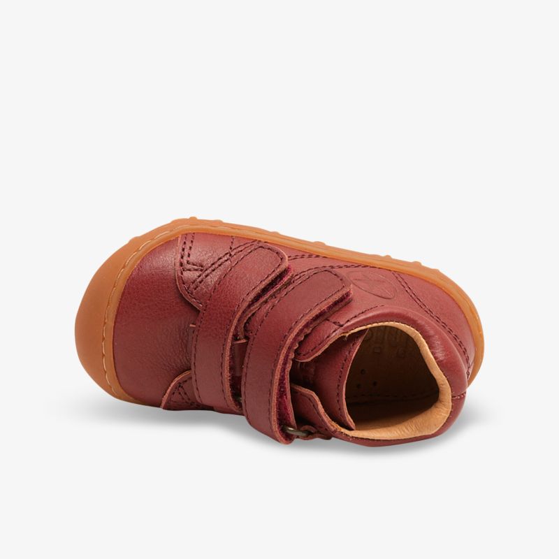 Roter Kinderschuh aus weichem Leder mit flexibler Sohle und praktischen Klettverschlüssen
