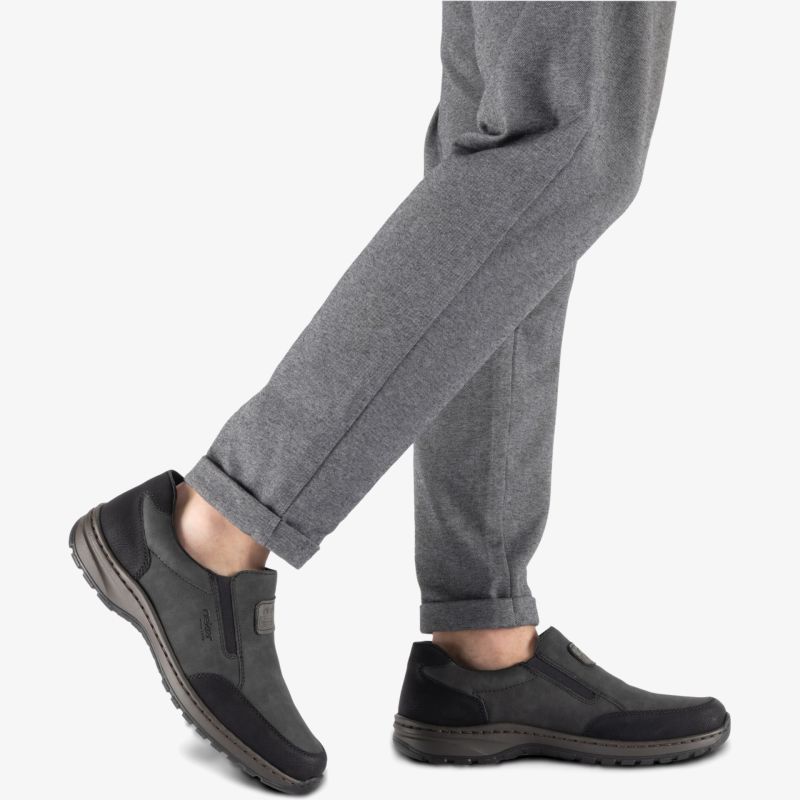 Bequeme schwarze Slipper mit robustem Design und griffiger Sohle.