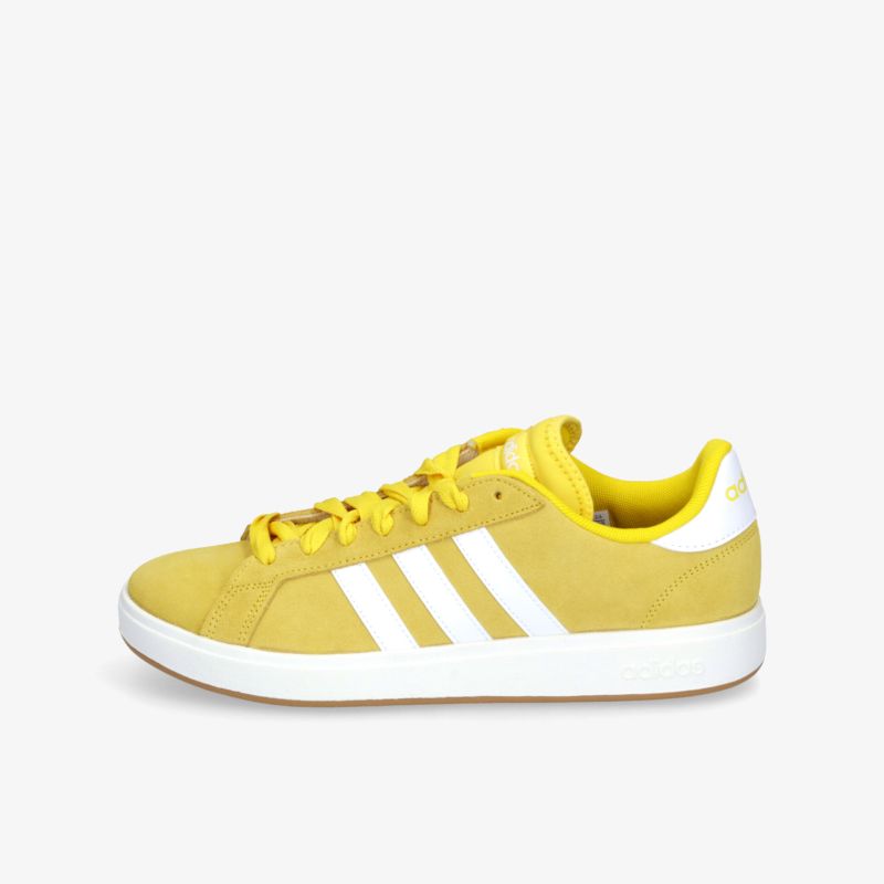 Moderner gelber Sneaker in seitlicher Ansicht mit weißer Sohle und drei weißen Streifen für sportlichen Komfort