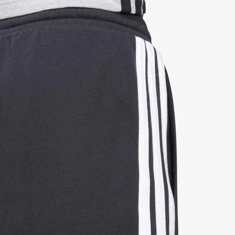 Schwarze Sporthose mit weißen Streifen, elastisches Material und präzise Nähte als Detailaufnahme