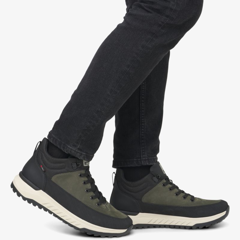 Sportliche und bequeme Schnürschuhe in Schwarz und Olive mit profilierter, flexibler Sohle getragen