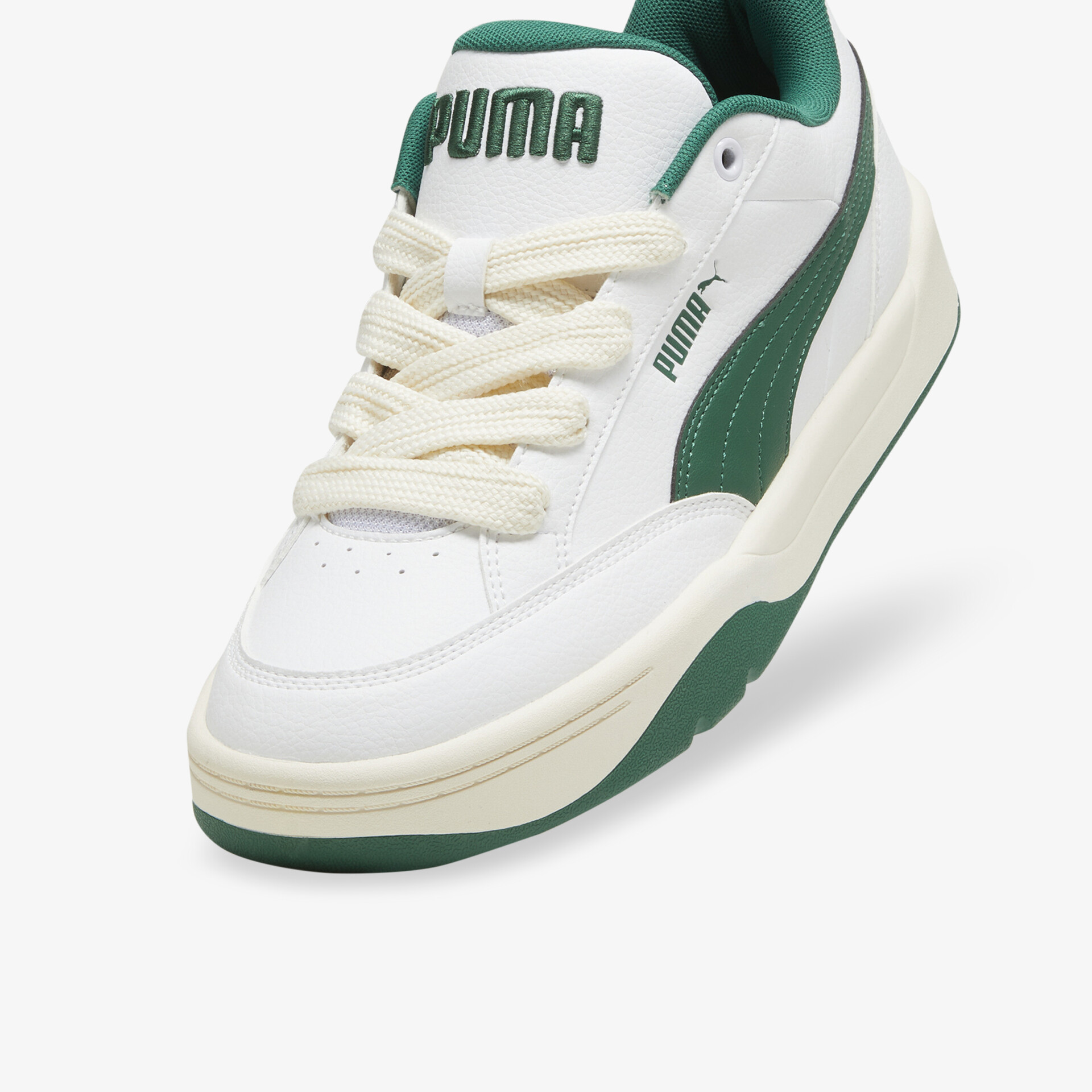 Weiß-grüner Puma Sneaker in schräger Vorderansicht mit gepolsterter Innenseite und robustem Design