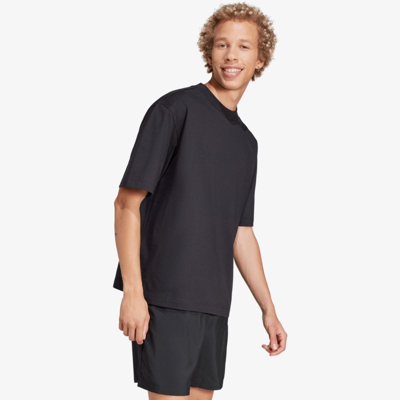 Mann trägt schwarzes klassisches T-Shirt und Shorts, bequemer Schnitt, lässiger und entspannter Stil