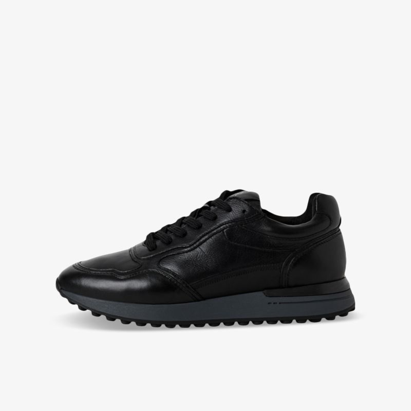 Schwarzer Sneaker mit weichem Material, rutschfester Sohle und modernem Design in klarer seitlicher Ansicht