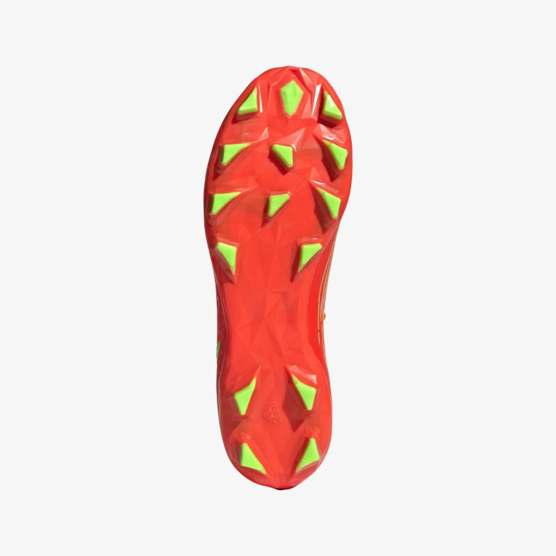 Rote Schuhsohle mit grünen Stollen für optimalen Halt und ausgezeichnete Griffigkeit auf dem Spielfeld.