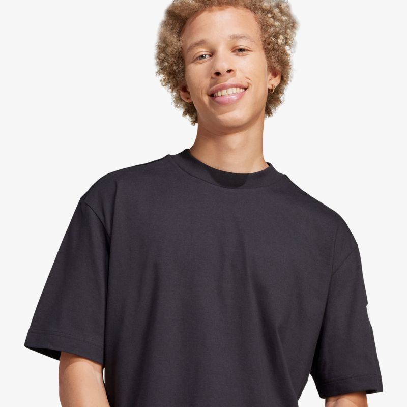Schwarzes lockeres T-Shirt mit Rundhalsausschnitt, komfortabel und lässig getragen auf hellem Hintergrund