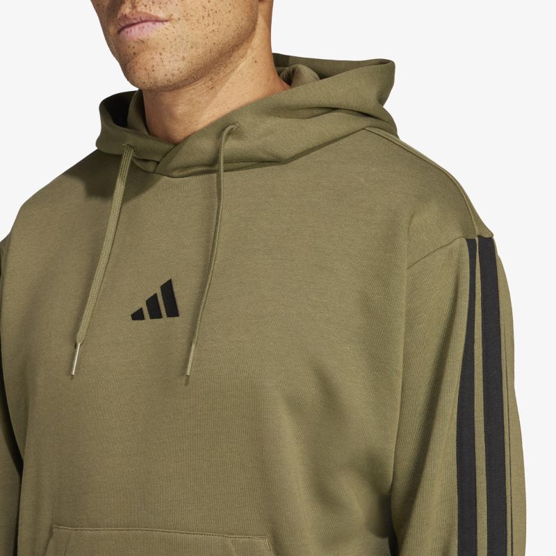 Detailaufnahme eines olivgrünen Kapuzenpullovers mit adidas-Logo und charakteristischen Streifen am Ärmel