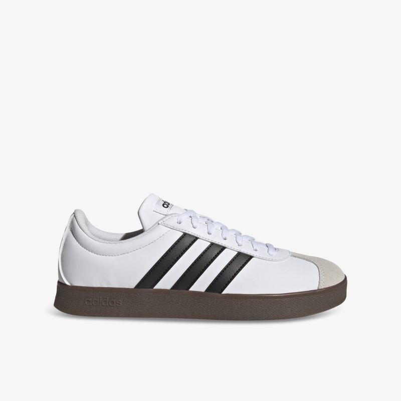 Seitliche Ansicht eines weißen Sneakers mit schwarzen Streifen, flacher Gummisohle und sportlichem Design.