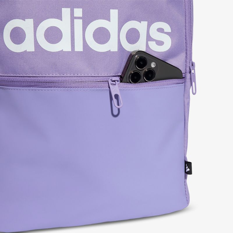 Detailaufnahme eines lila adidas Rucksacks mit sichtbarem Reißverschluss und Smartphone in Fronttasche